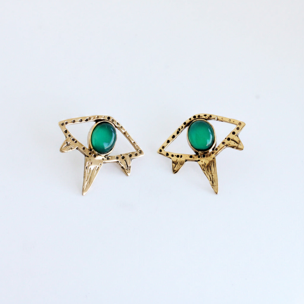 Gold earrings with green gemstones on a white background