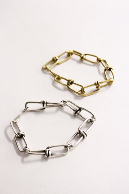 Two chain-link bracelets, one gold and one silver