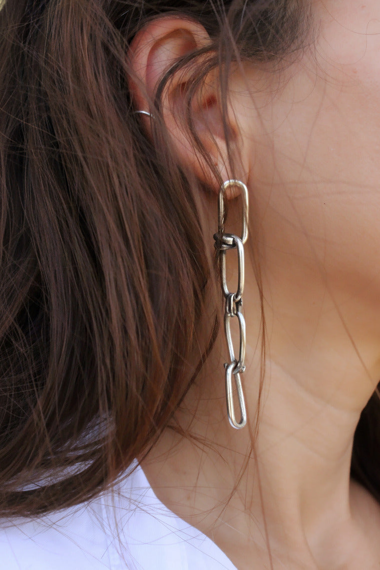  a silver chain earring.