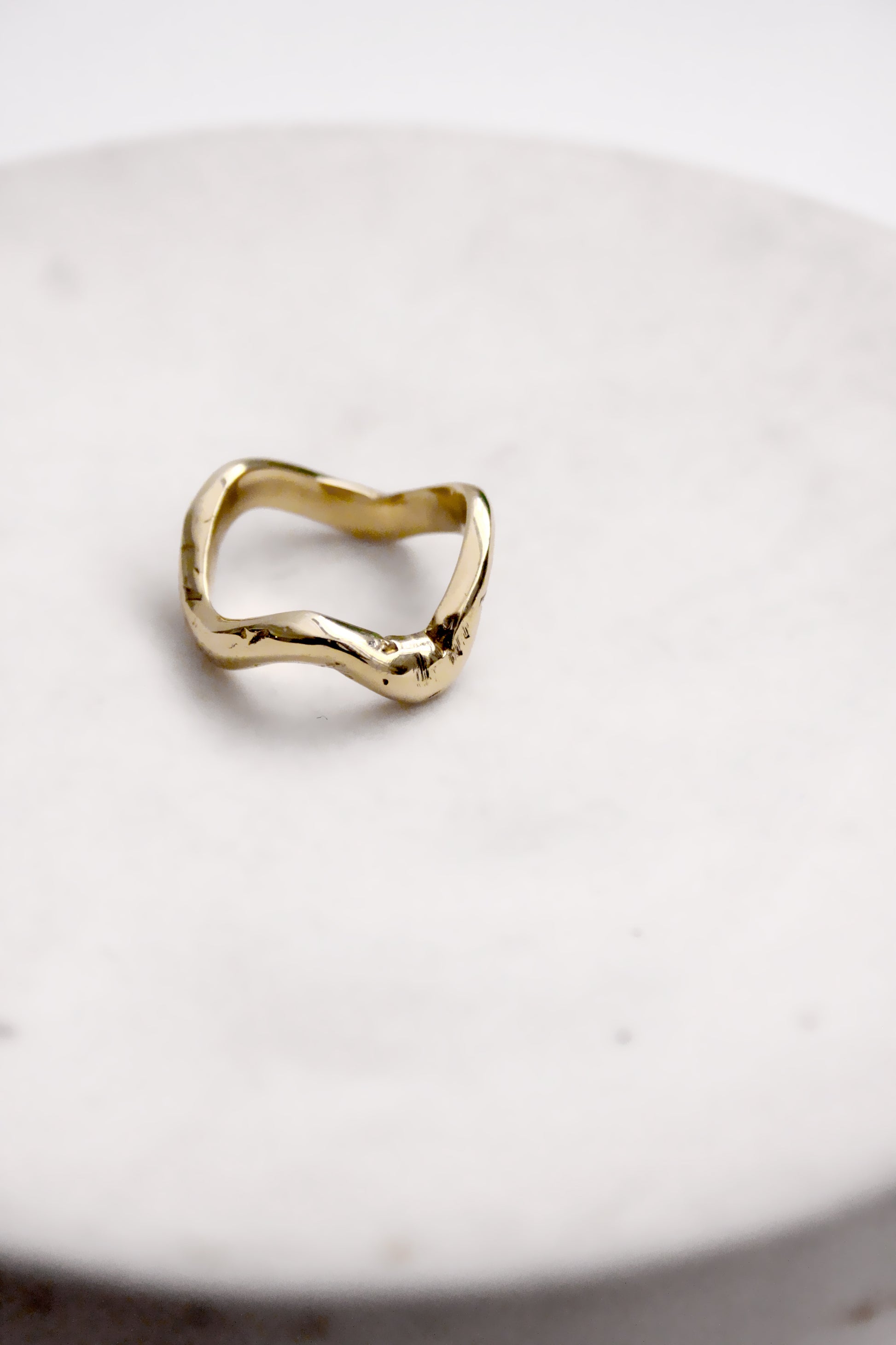 Gold ring on a white marble surface