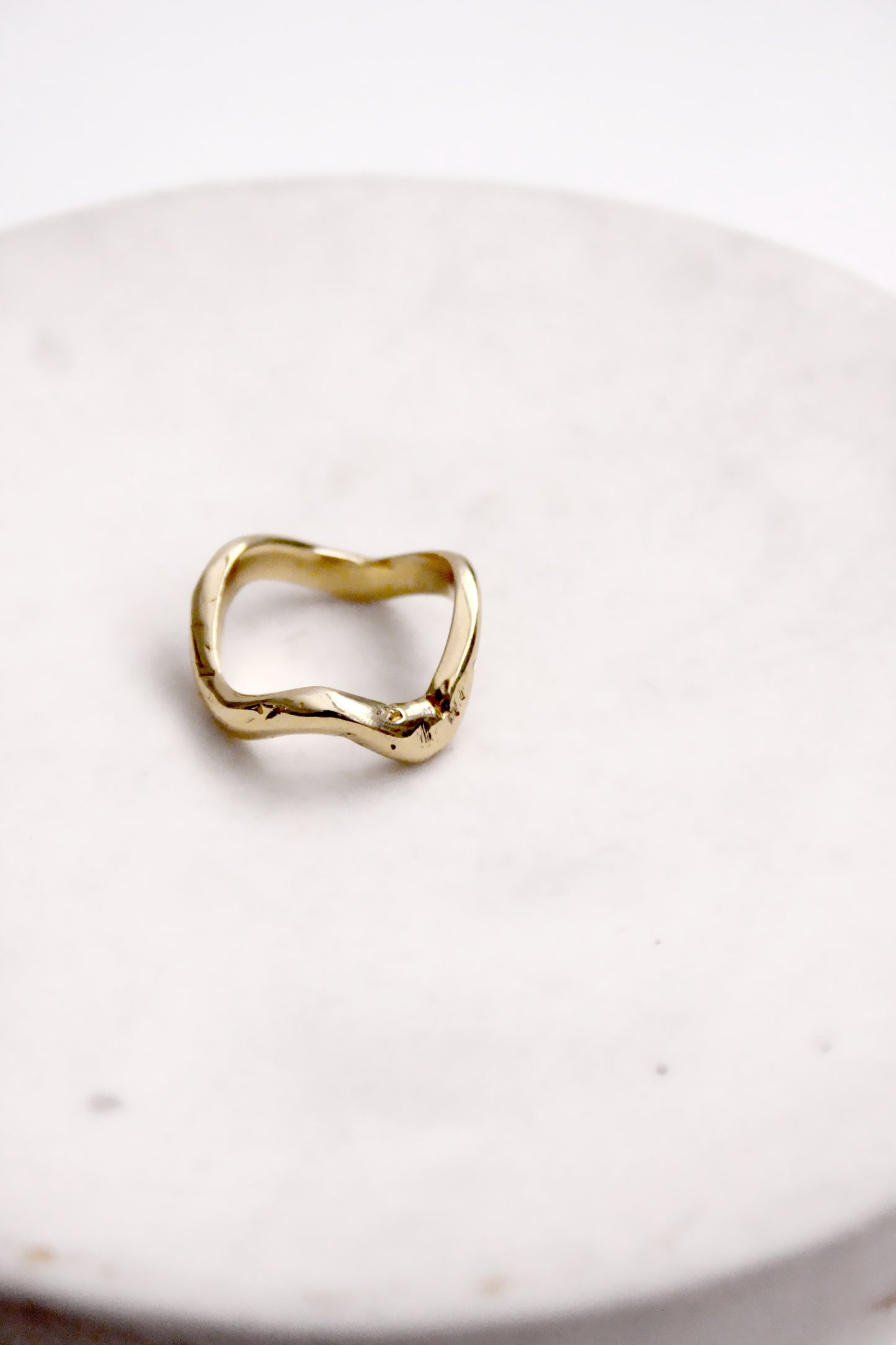 Gold ring on a white ceramic plate