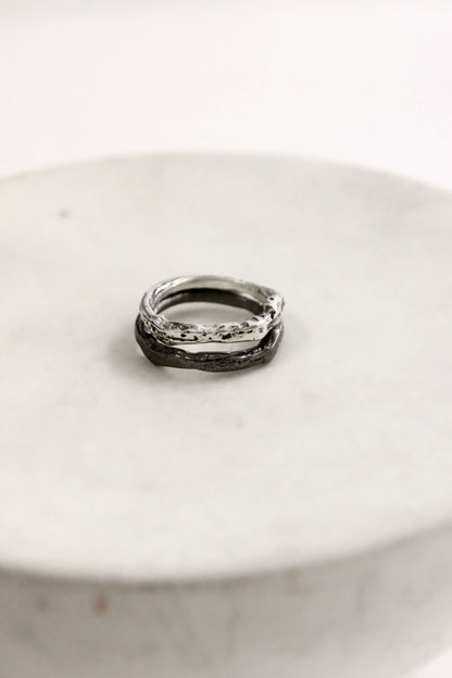 Two silver rings on a white ceramic plate