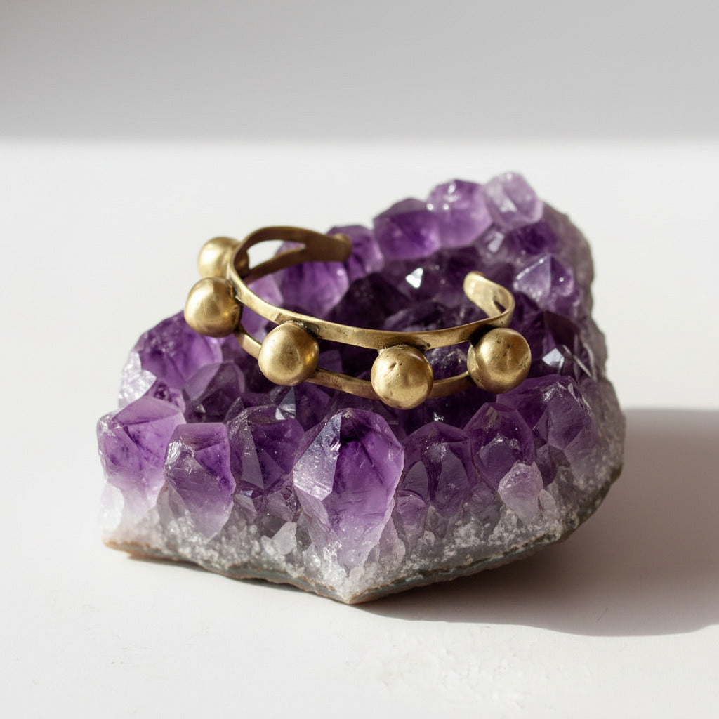 Gold bracelet with spherical ends on a white background