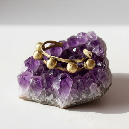 Gold bracelet with spherical ends on a white background
