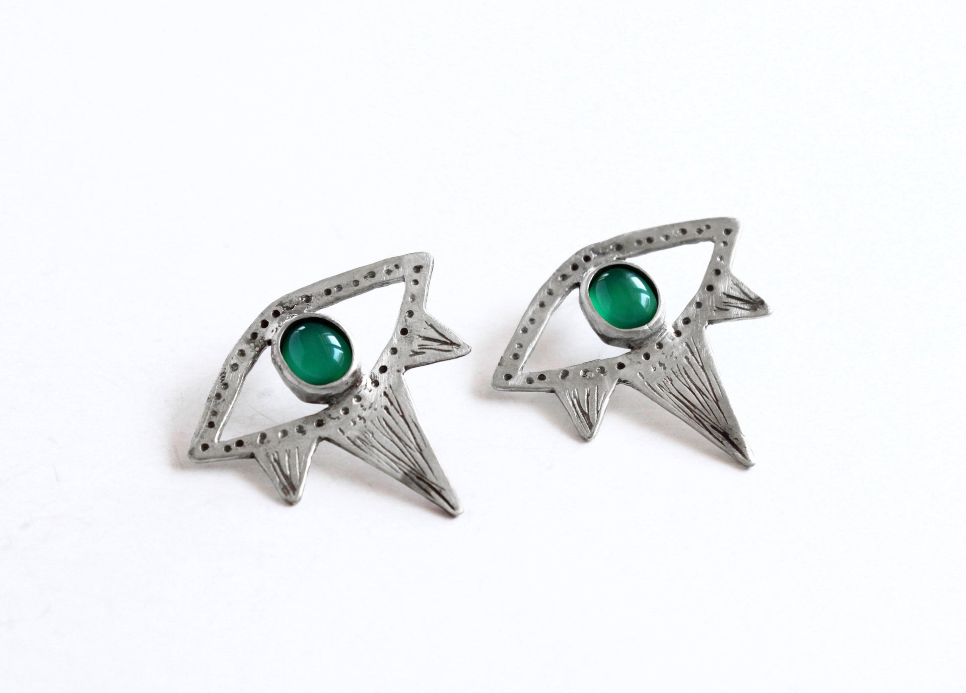 Pair of silver eyes earrings with green gemstones 