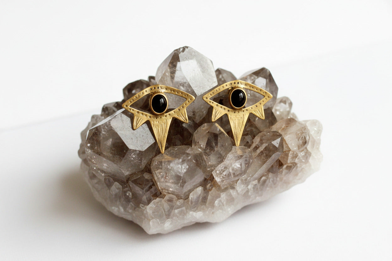 Gold eye-shaped earrings with black gemstones 