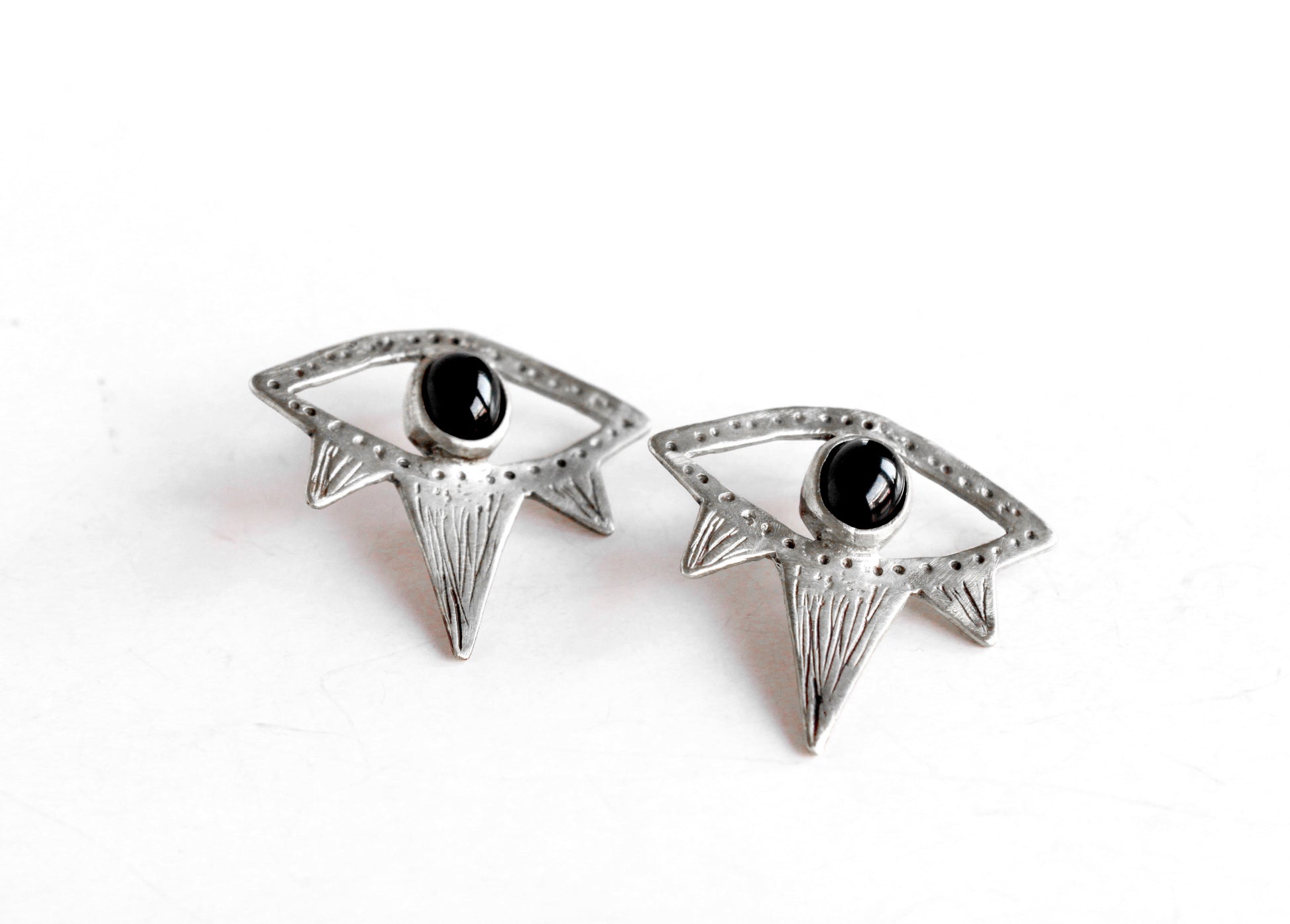 Pair of silver eyes earrings with black gemstones