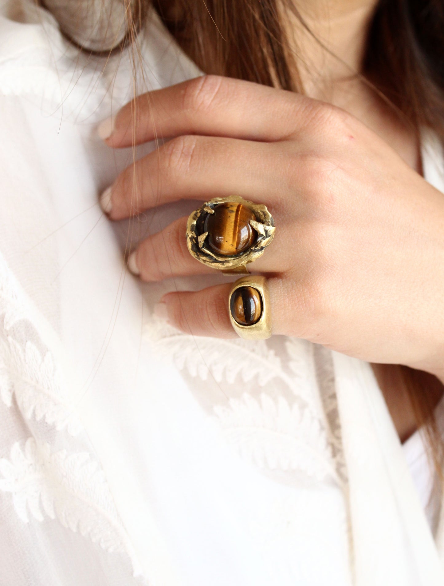 two gold rings with tiger's eye stones