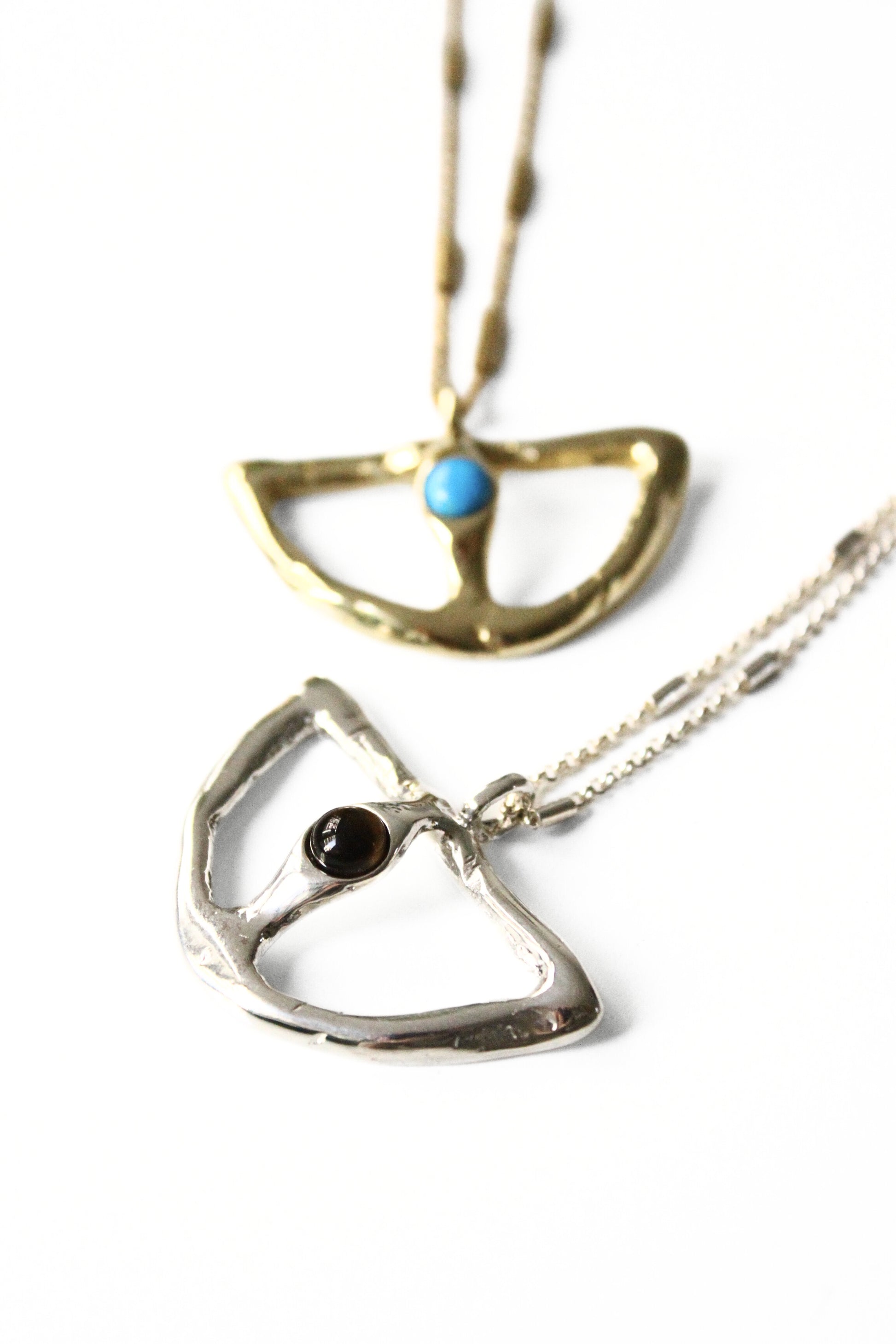 Two necklaces with unique pendants on a white background
