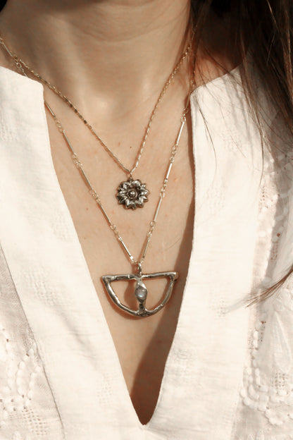  two necklaces with floral and geometric pendants 