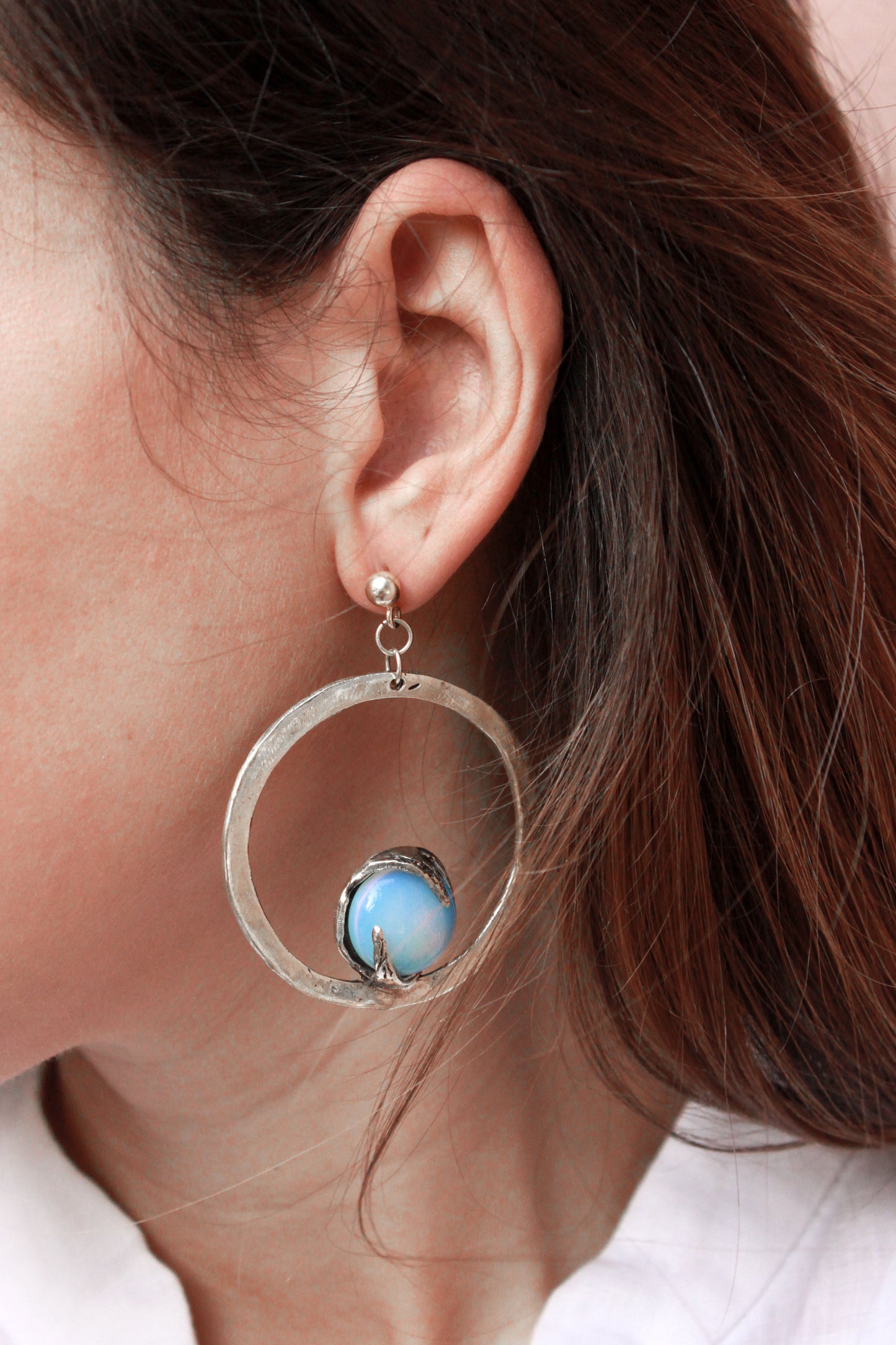 silver hoop earring with a opal gemstone.