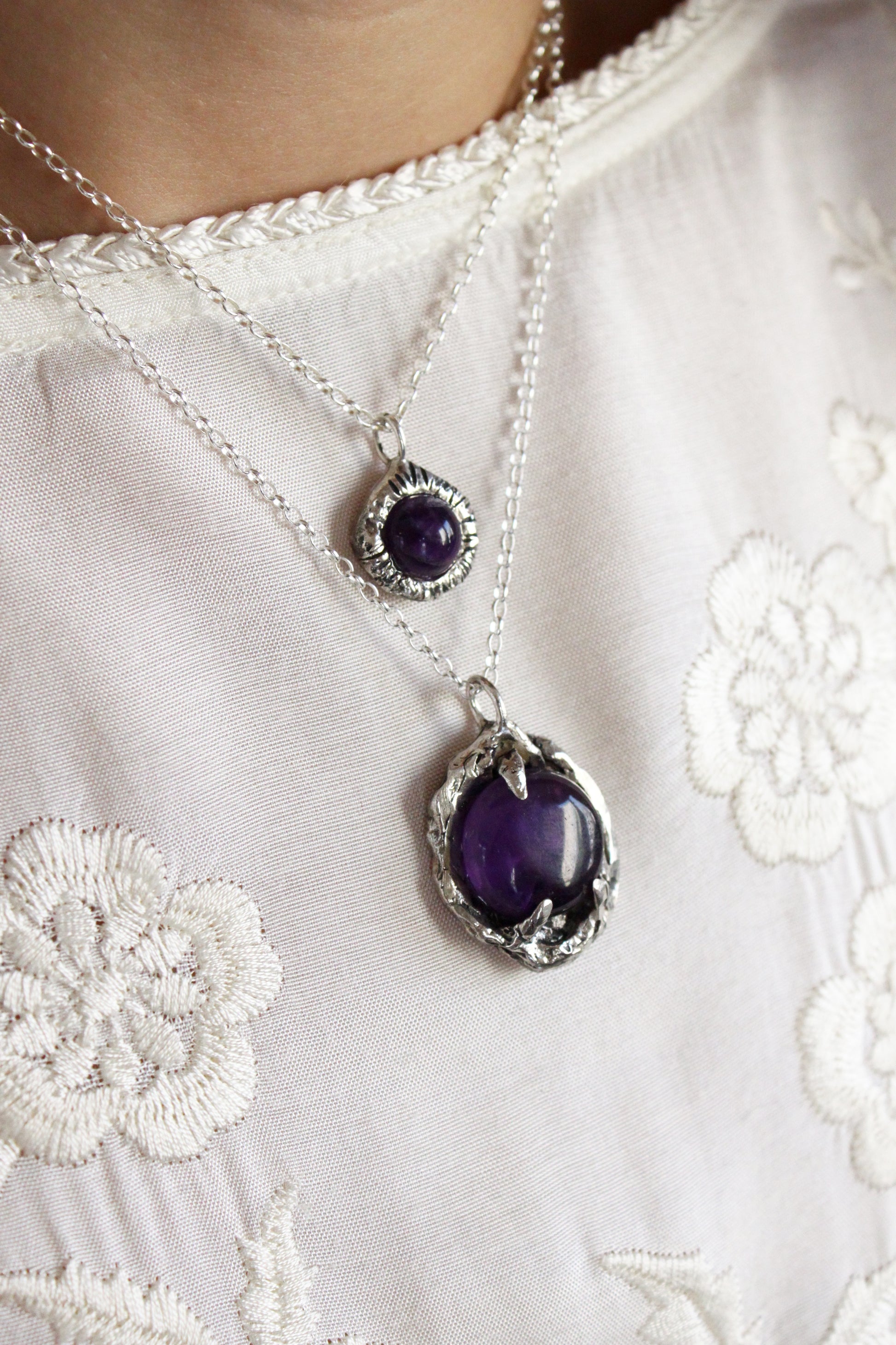 Two silver necklaces with purple stones 