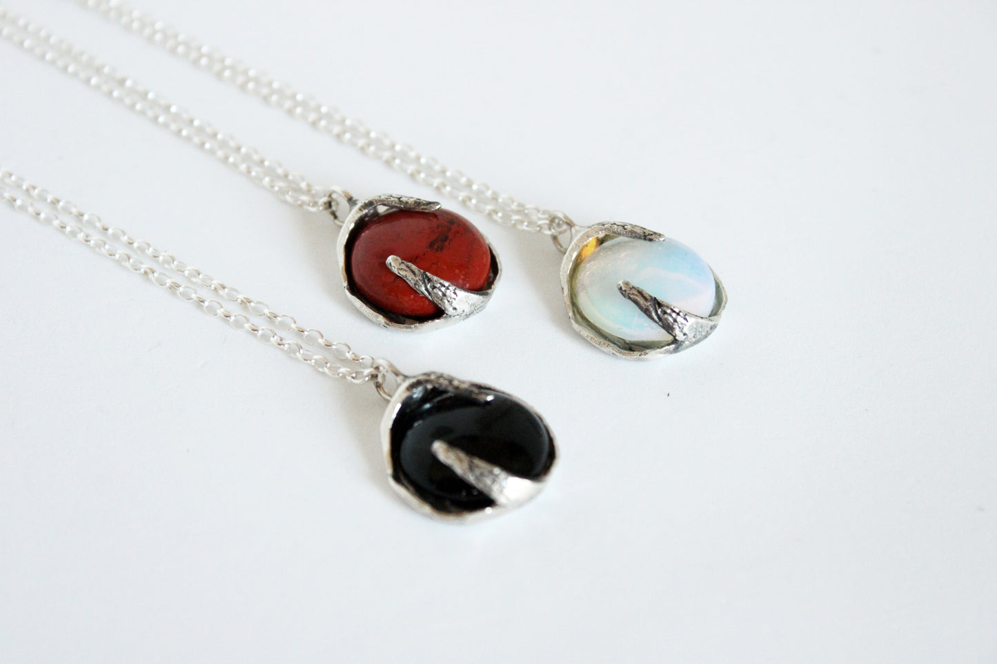 Three silver necklaces with different colored crystals