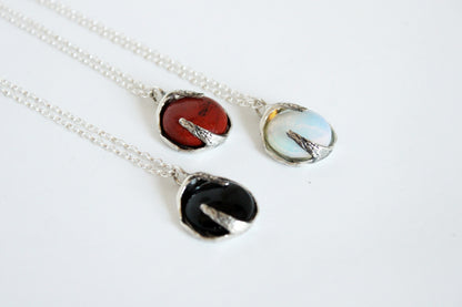 Three silver necklaces with different colored crystals