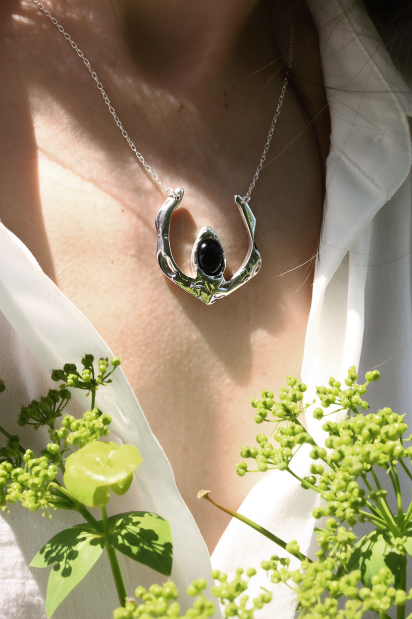 Necklace with a pendant featuring a black stone 