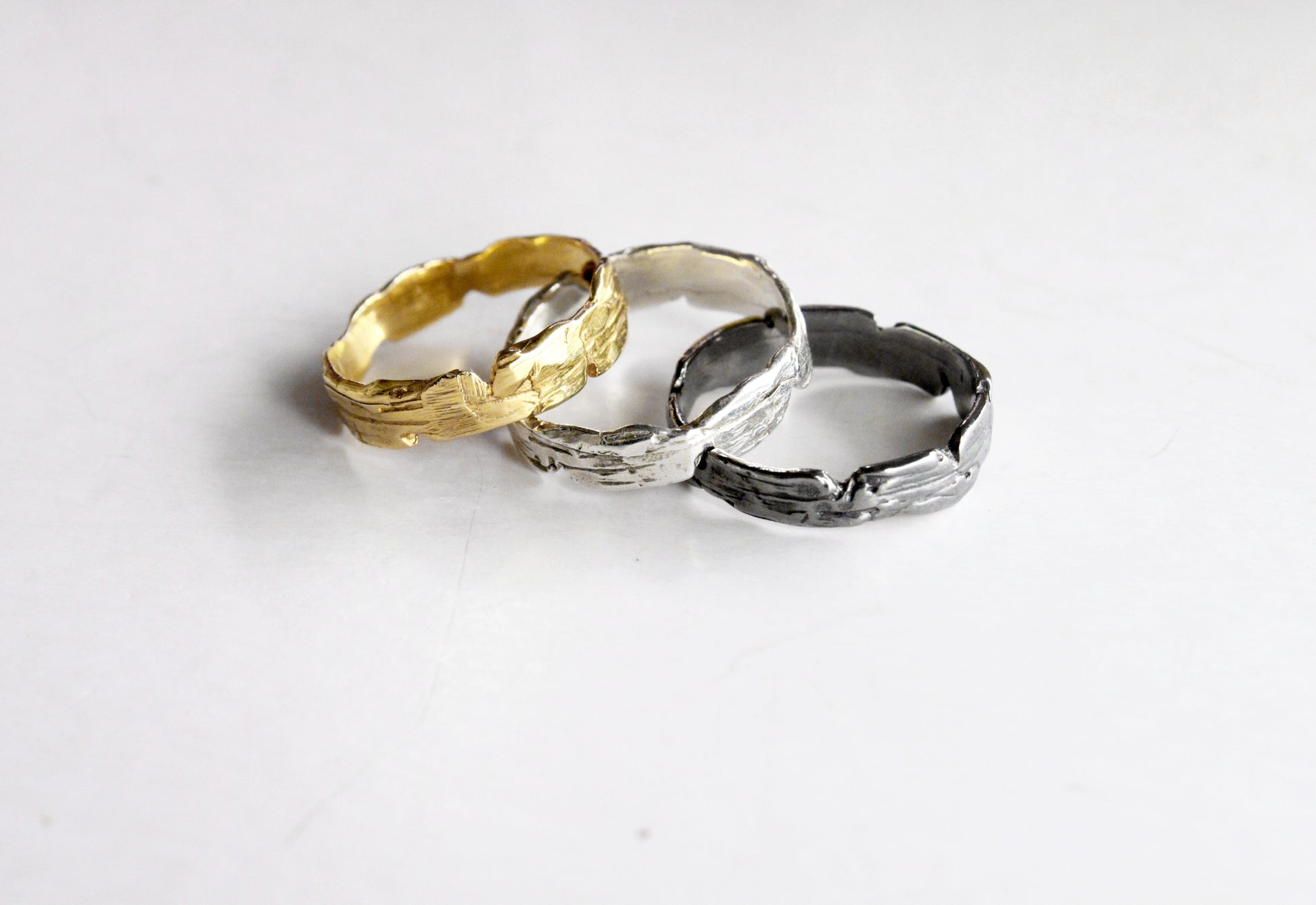 Three rings in gold, silver, and black 