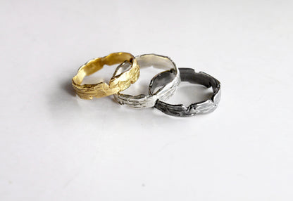 Three rings in gold, silver, and black 