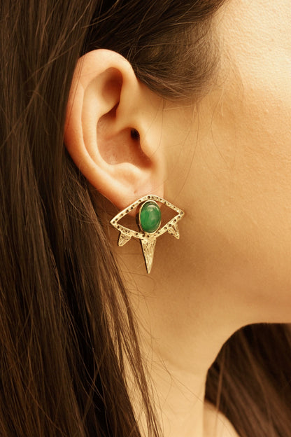 Eye earring with a green gemstone.
