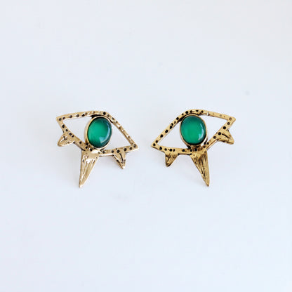 Gold earrings with green gemstones on a white background