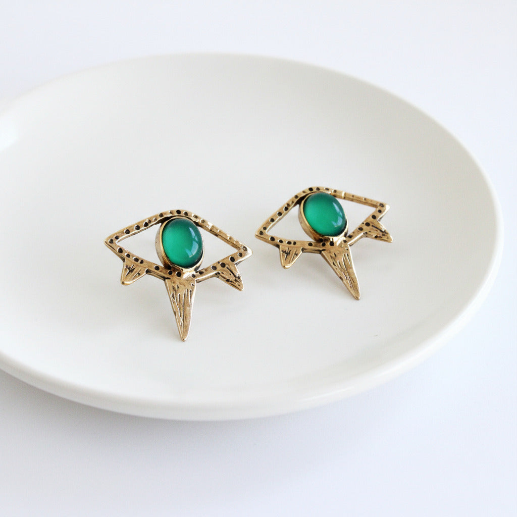Gold earrings with green gemstones on a white background