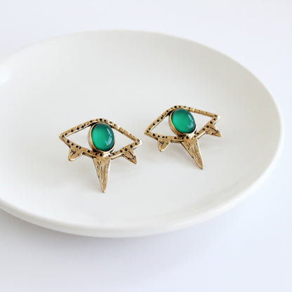 Gold earrings with green gemstones on a white background