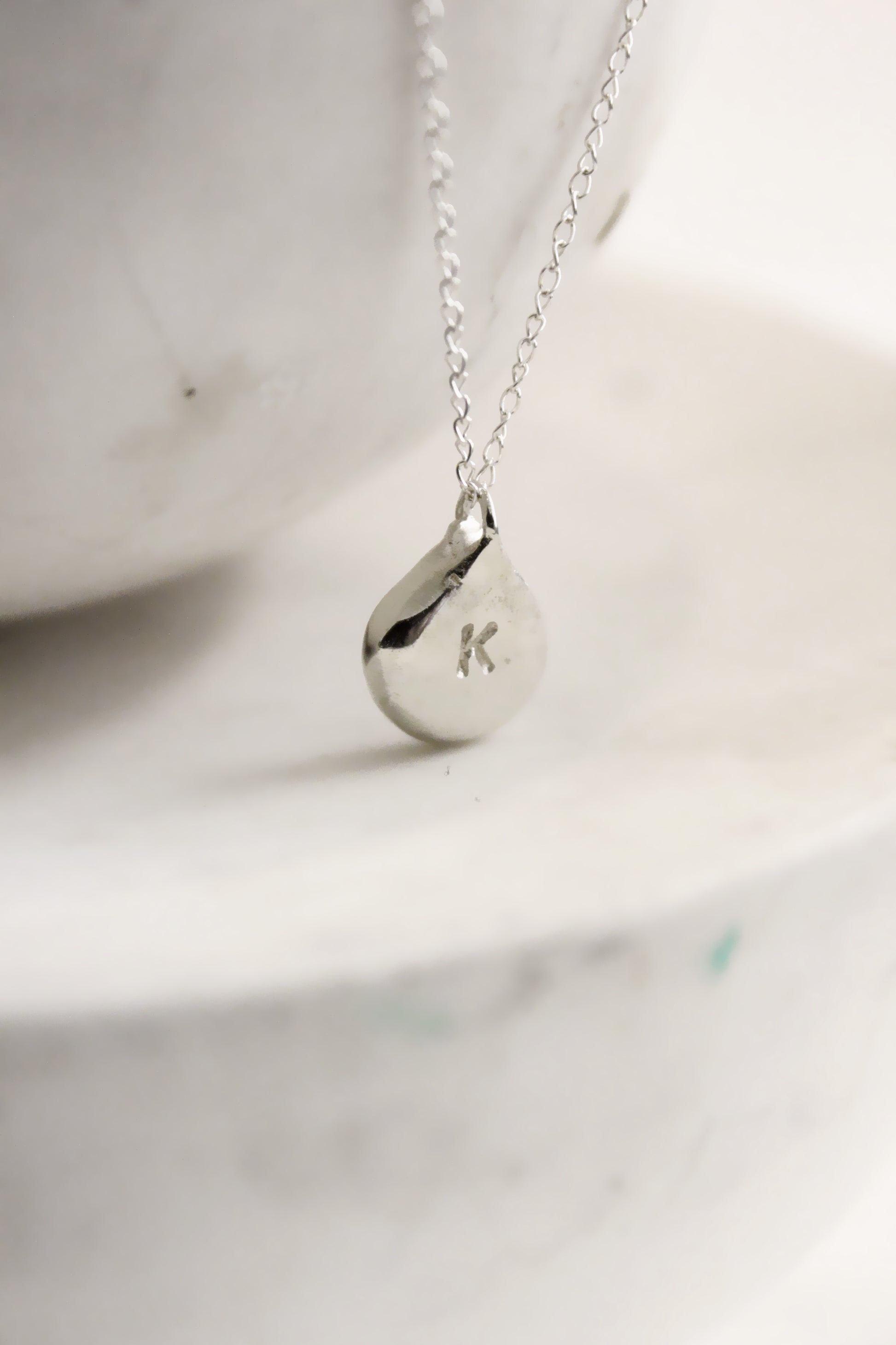 Silver necklace with a teardrop-shaped personalized initials monogram 