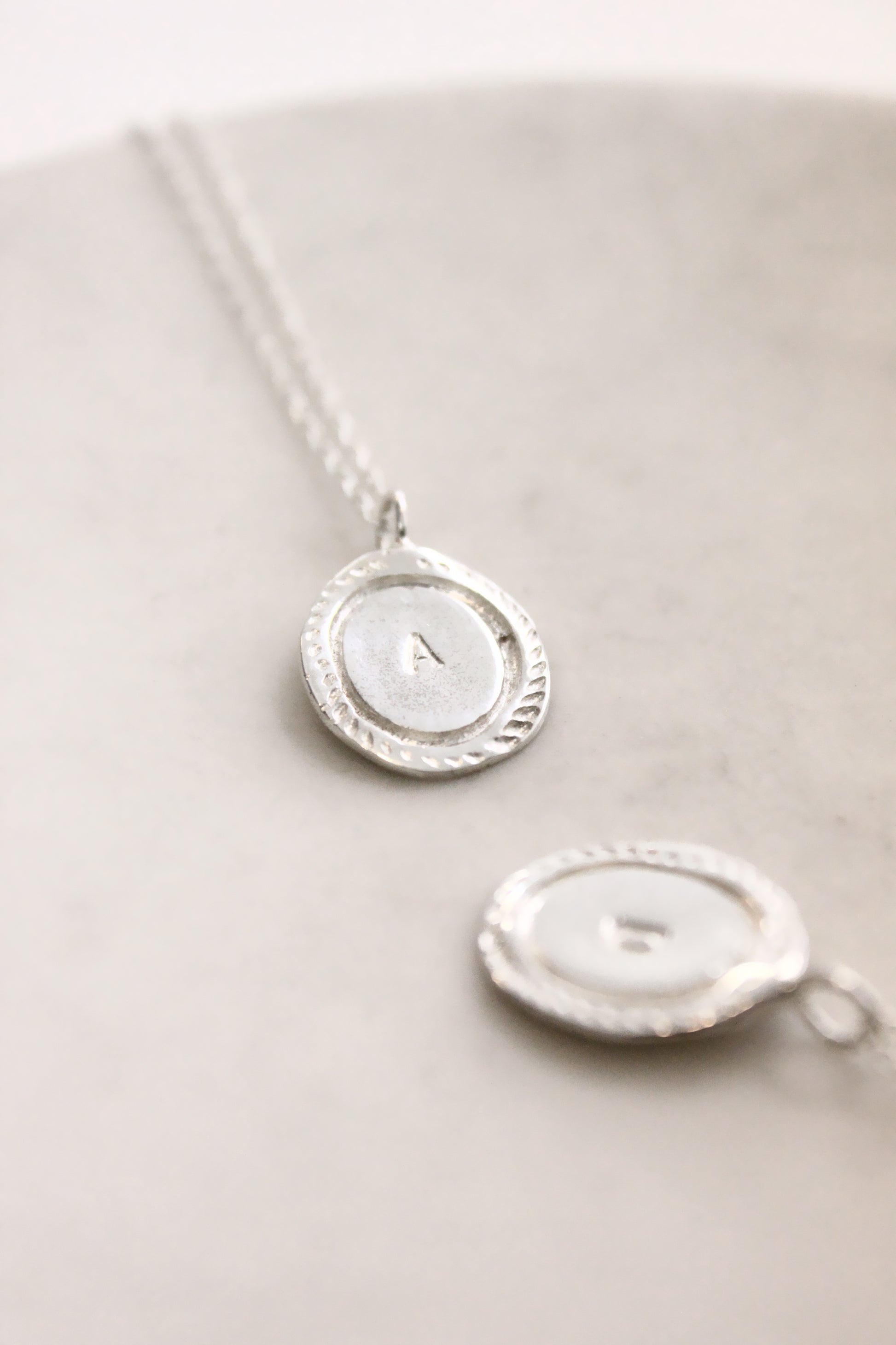 Silver necklace with a round pendant personalized initials monogram
