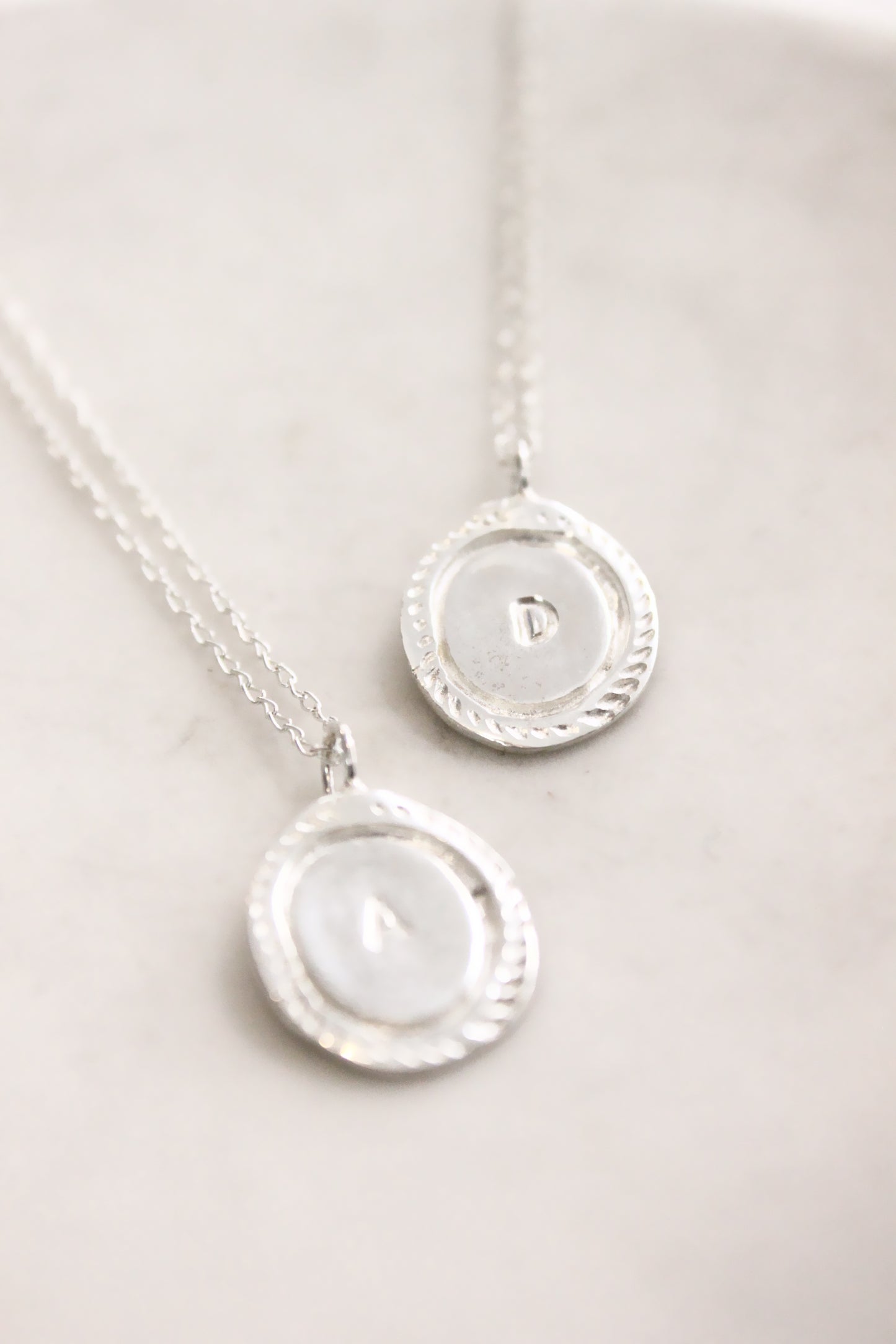 Two silver necklaces with circular pendants  personalized initials monogram