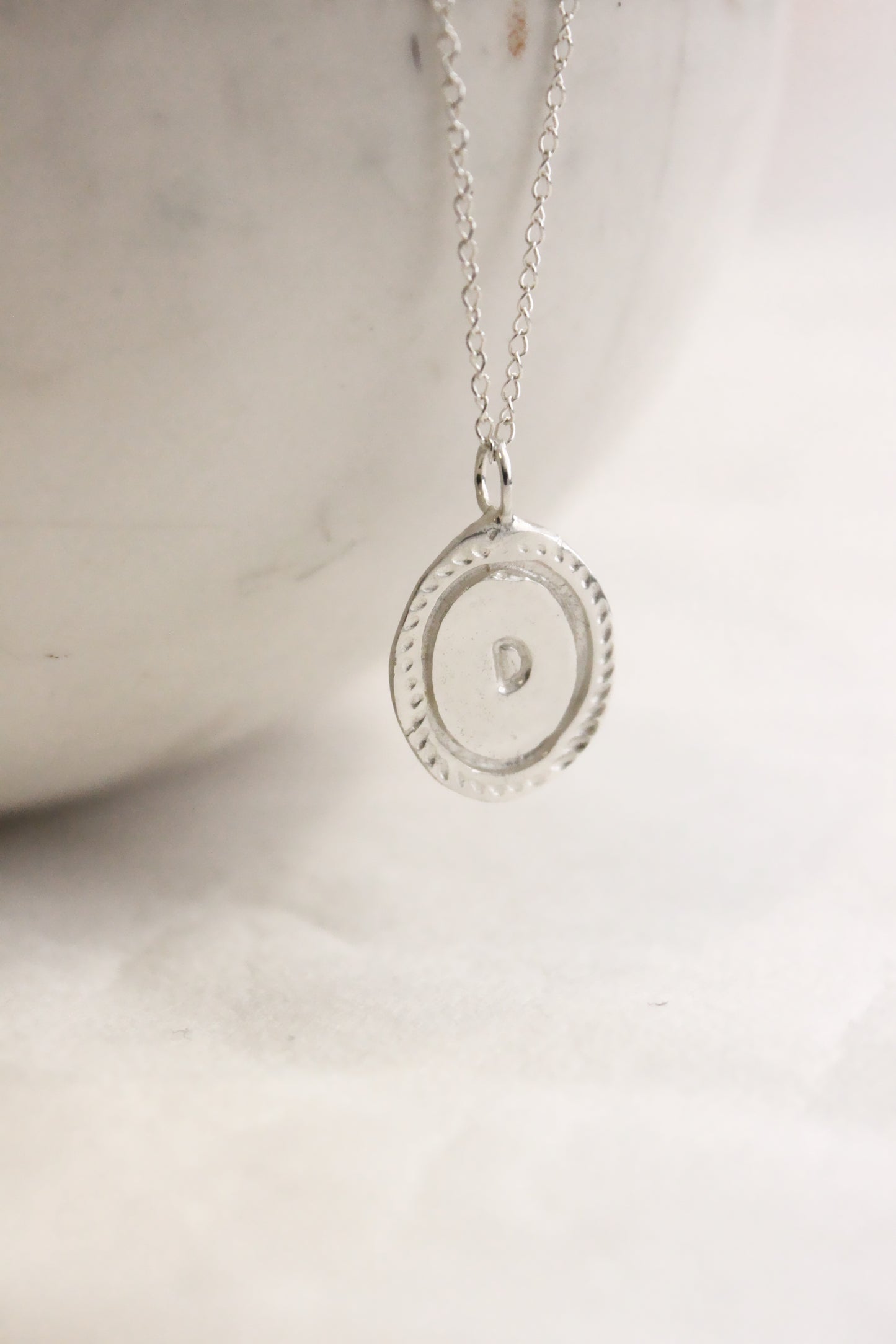 Silver necklace with a round personalized initials monogram 