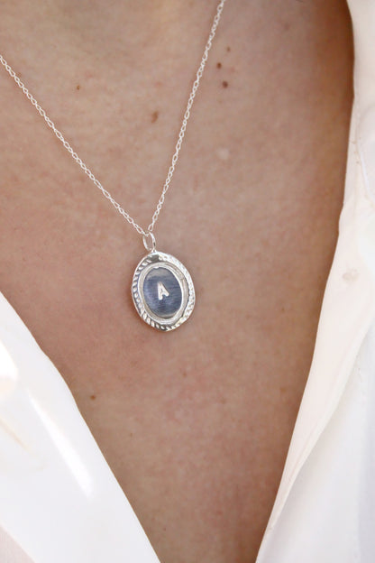Silver necklace with a pendant on a person's neck
