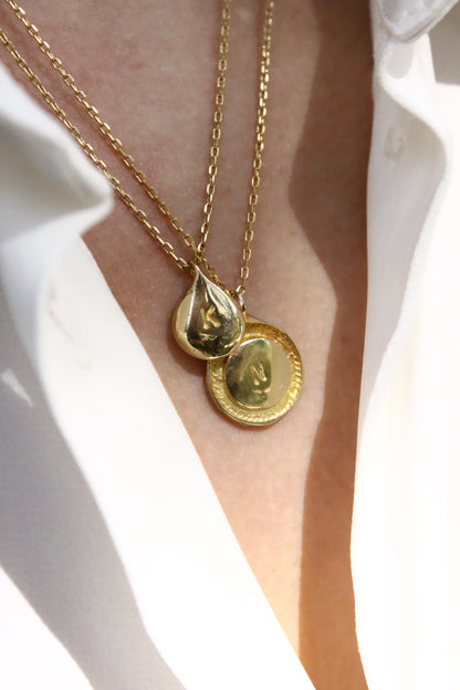 Gold necklaces with circular monogram pendants 