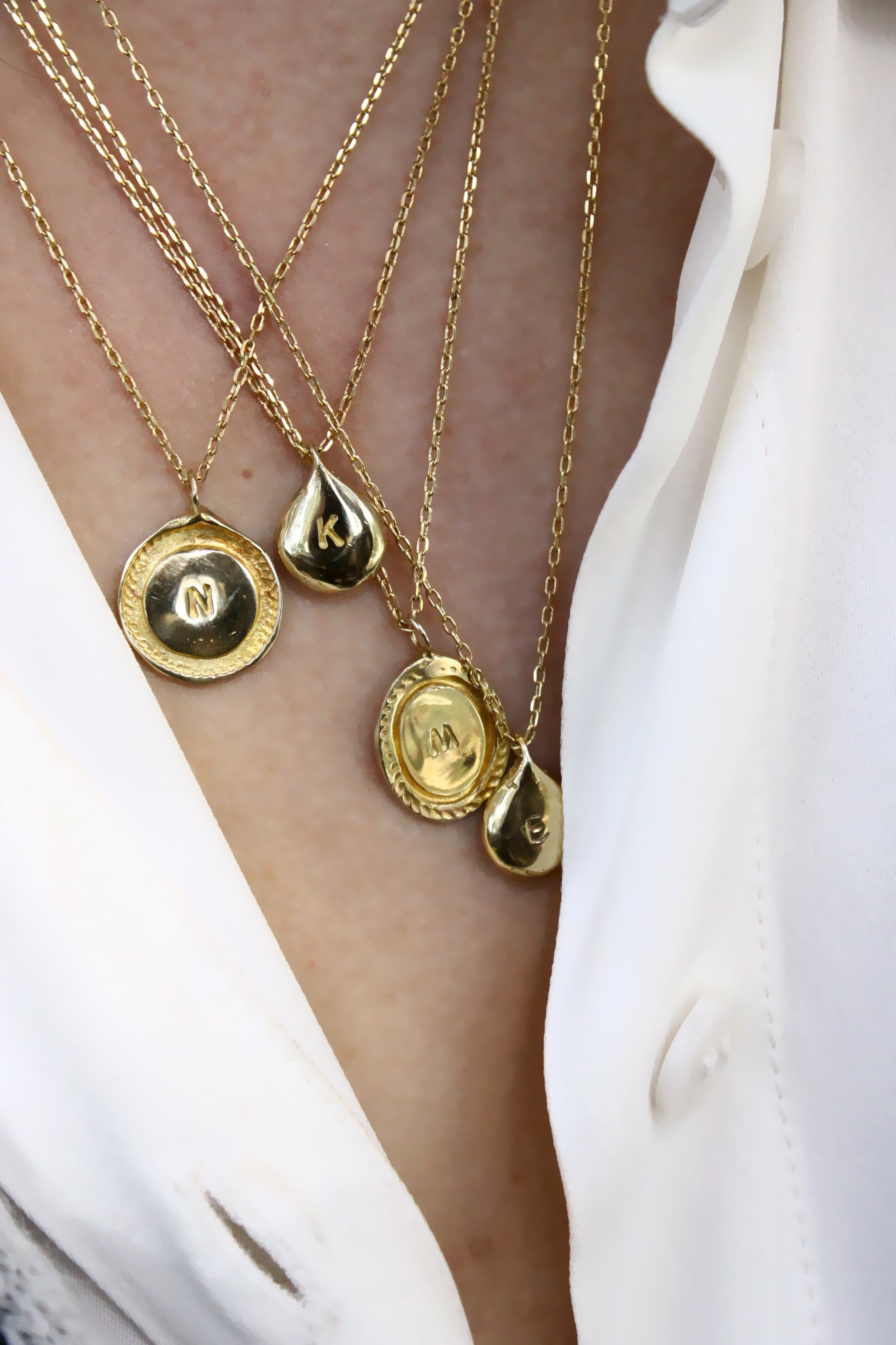 Gold necklaces with circular and teardrop pendants personalized initials