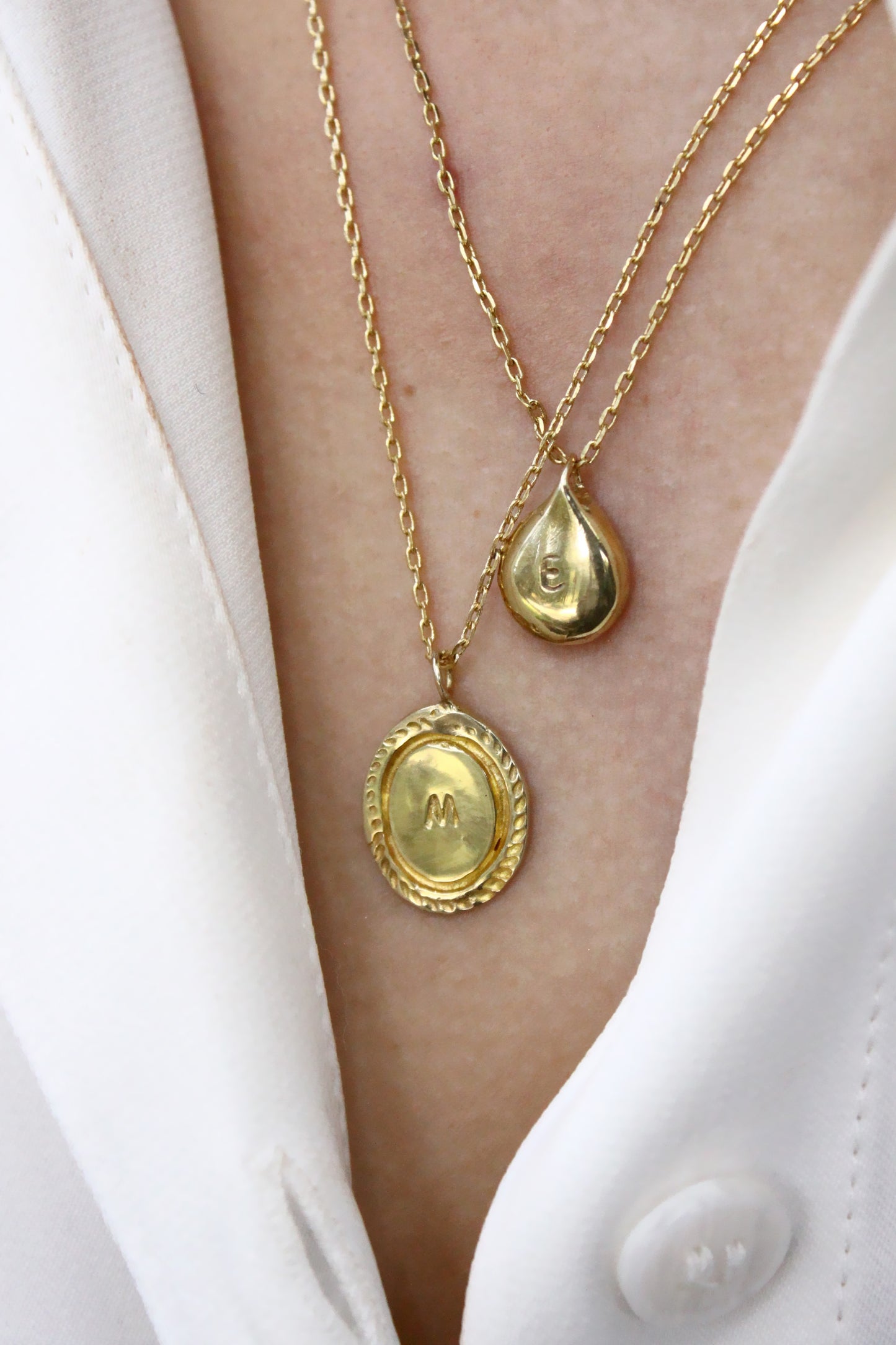 Two gold necklaces with monogram