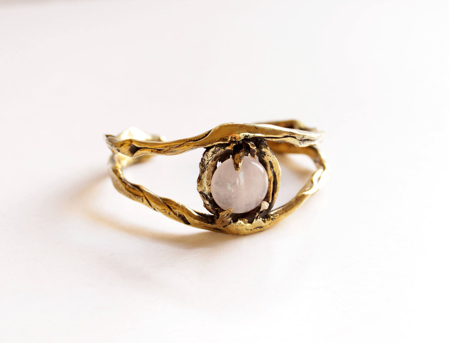 Gold cuff eye bracelet with a central stone 