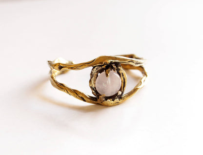 Gold cuff eye bracelet with a central stone 