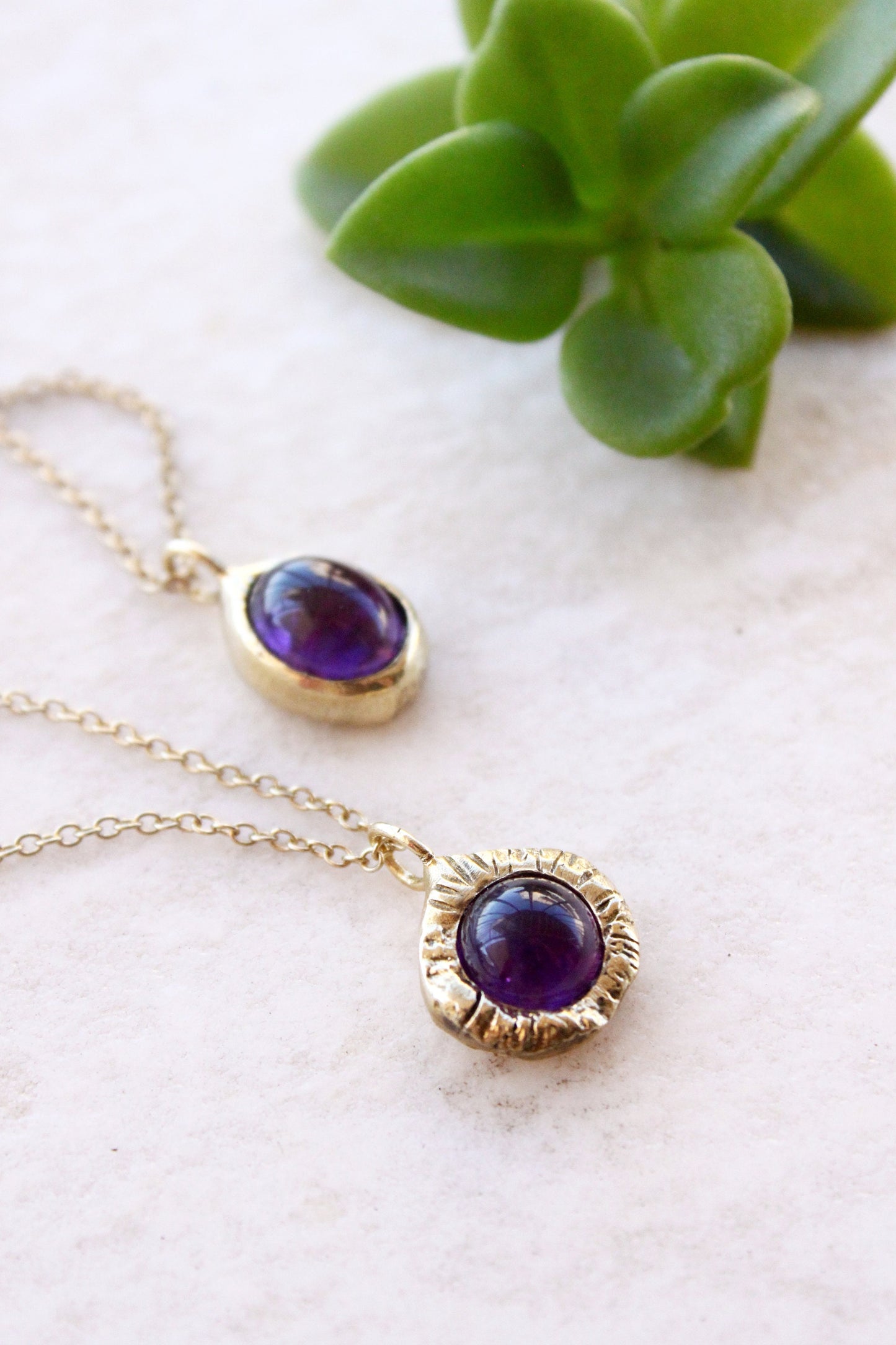 Gold necklaces with purple amethyst gemstones.