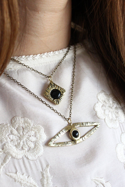Two gold necklaces with eye designs black onyx