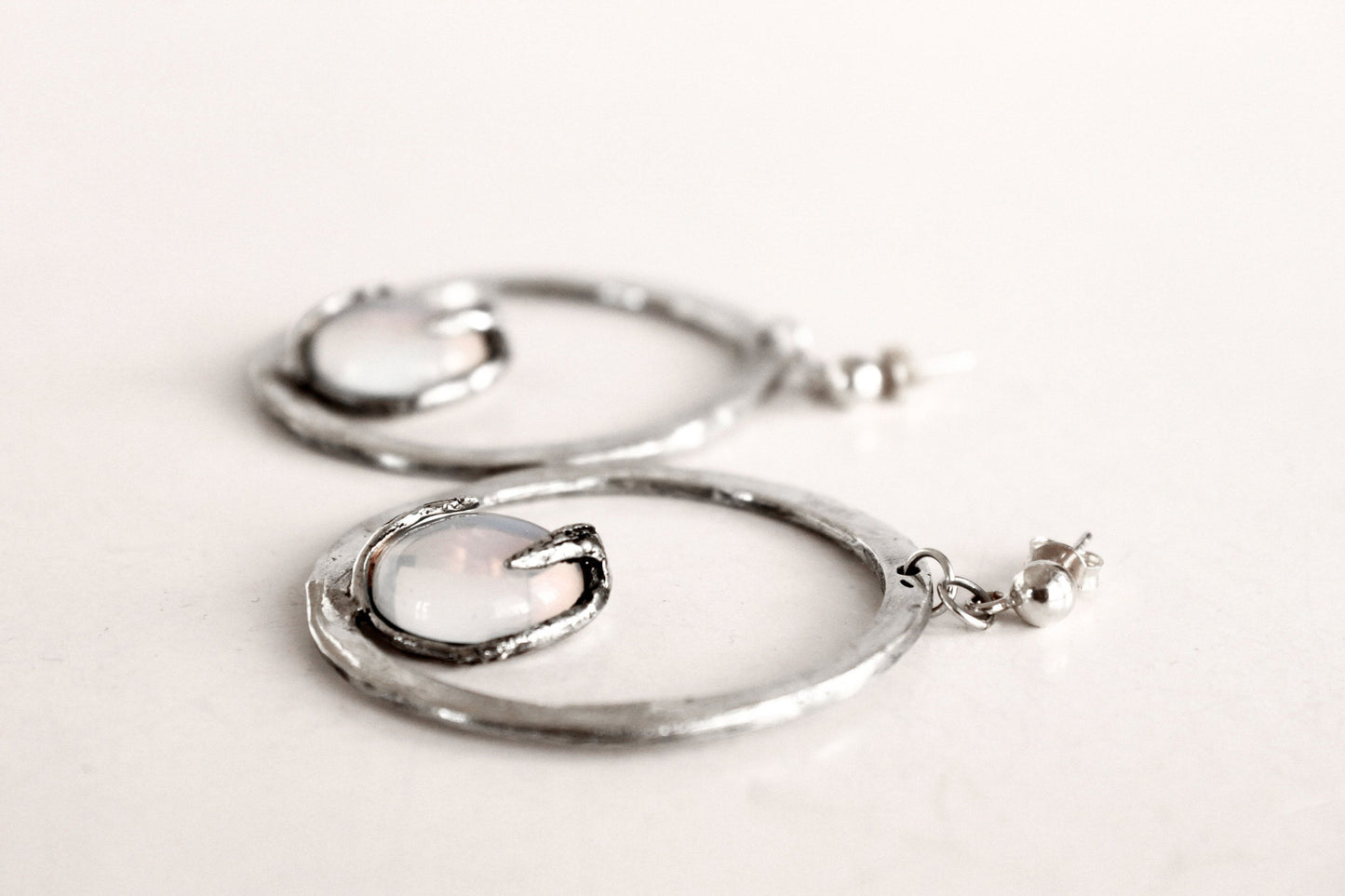 Silver hoop earrings with a central gemstone 