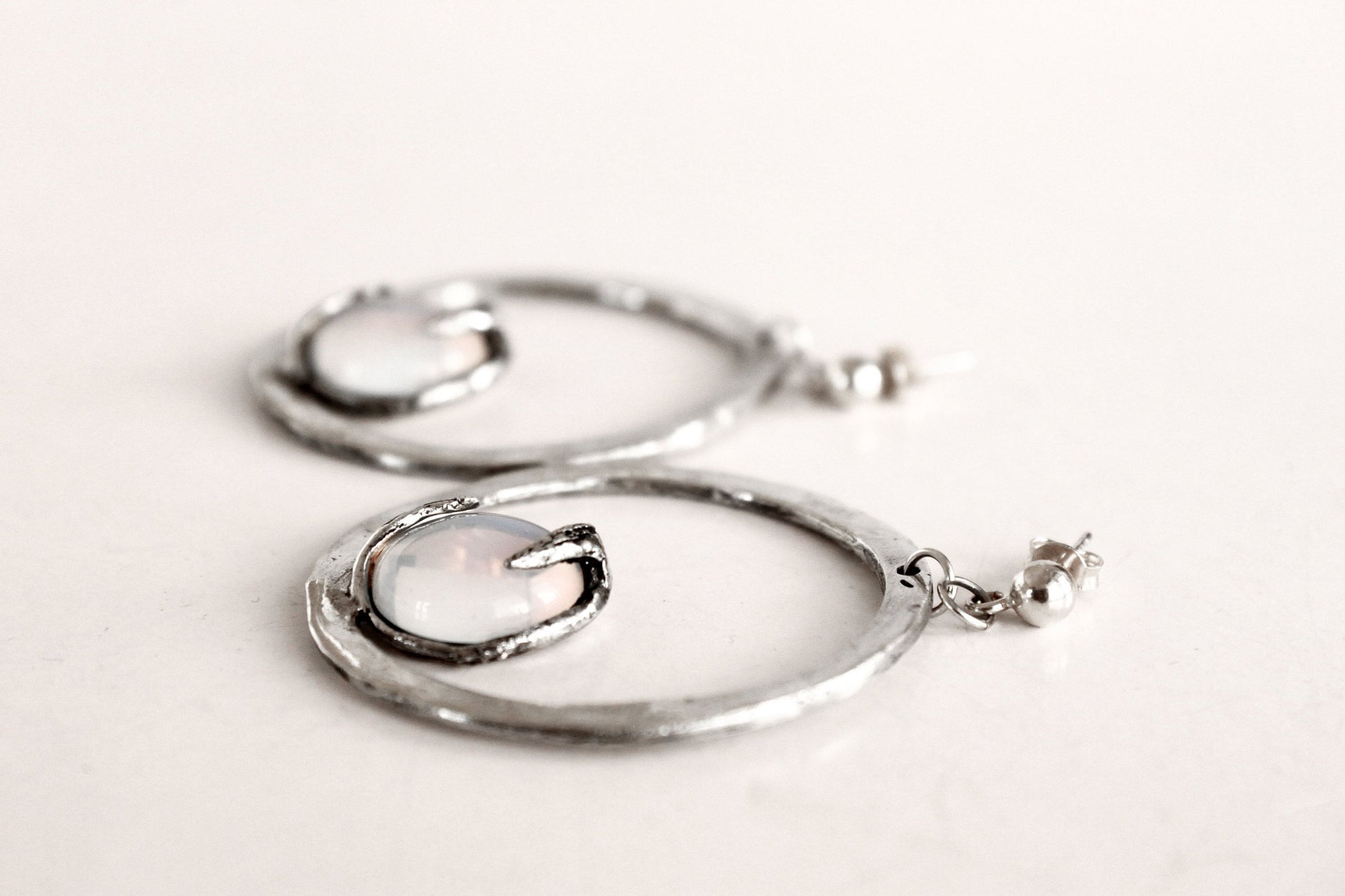 Silver hoop earrings with a central gemstone 
