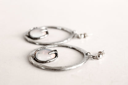 Silver hoop earrings with a central gemstone 