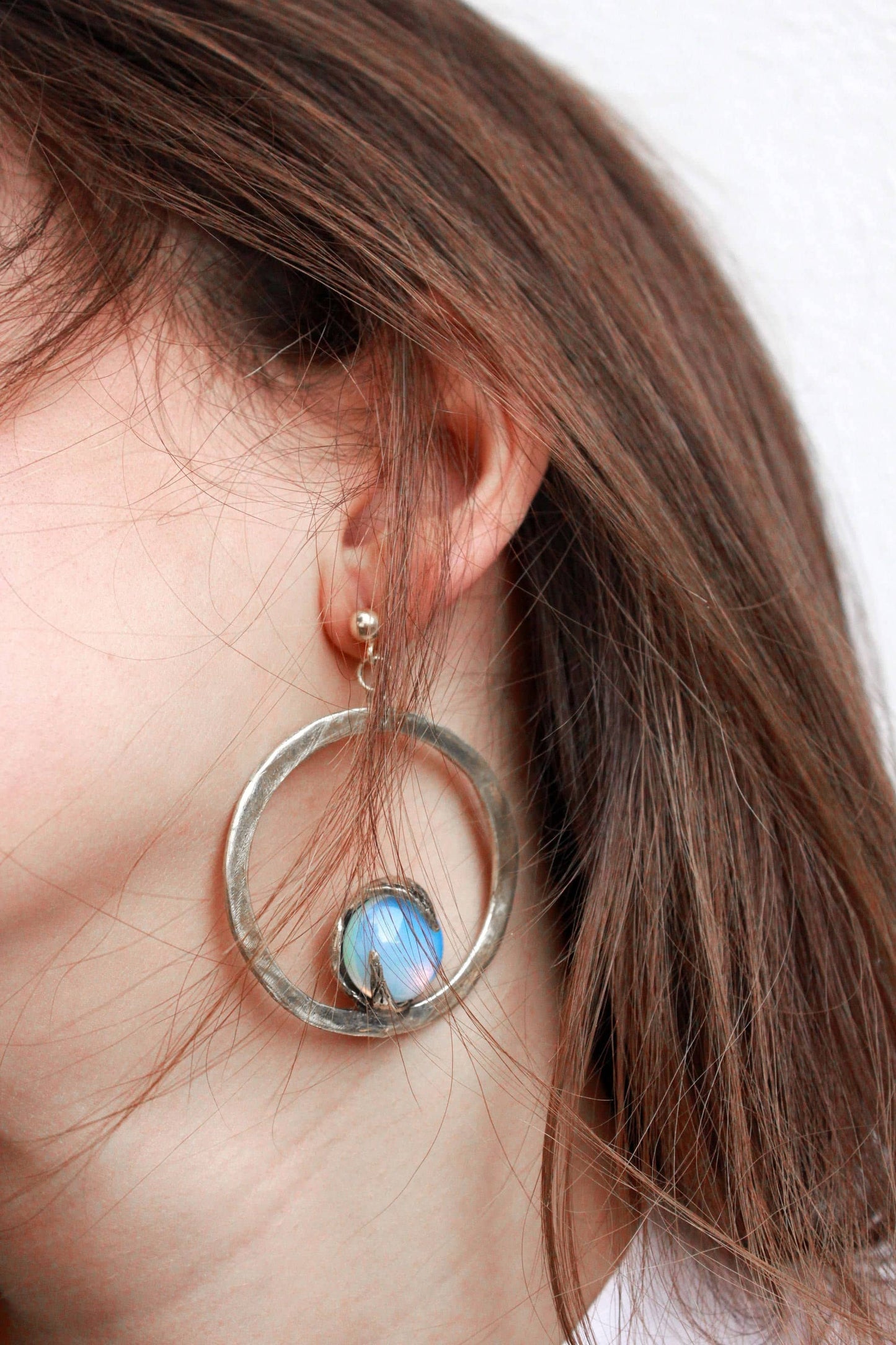 silver hoop earring with a opal gemstone.