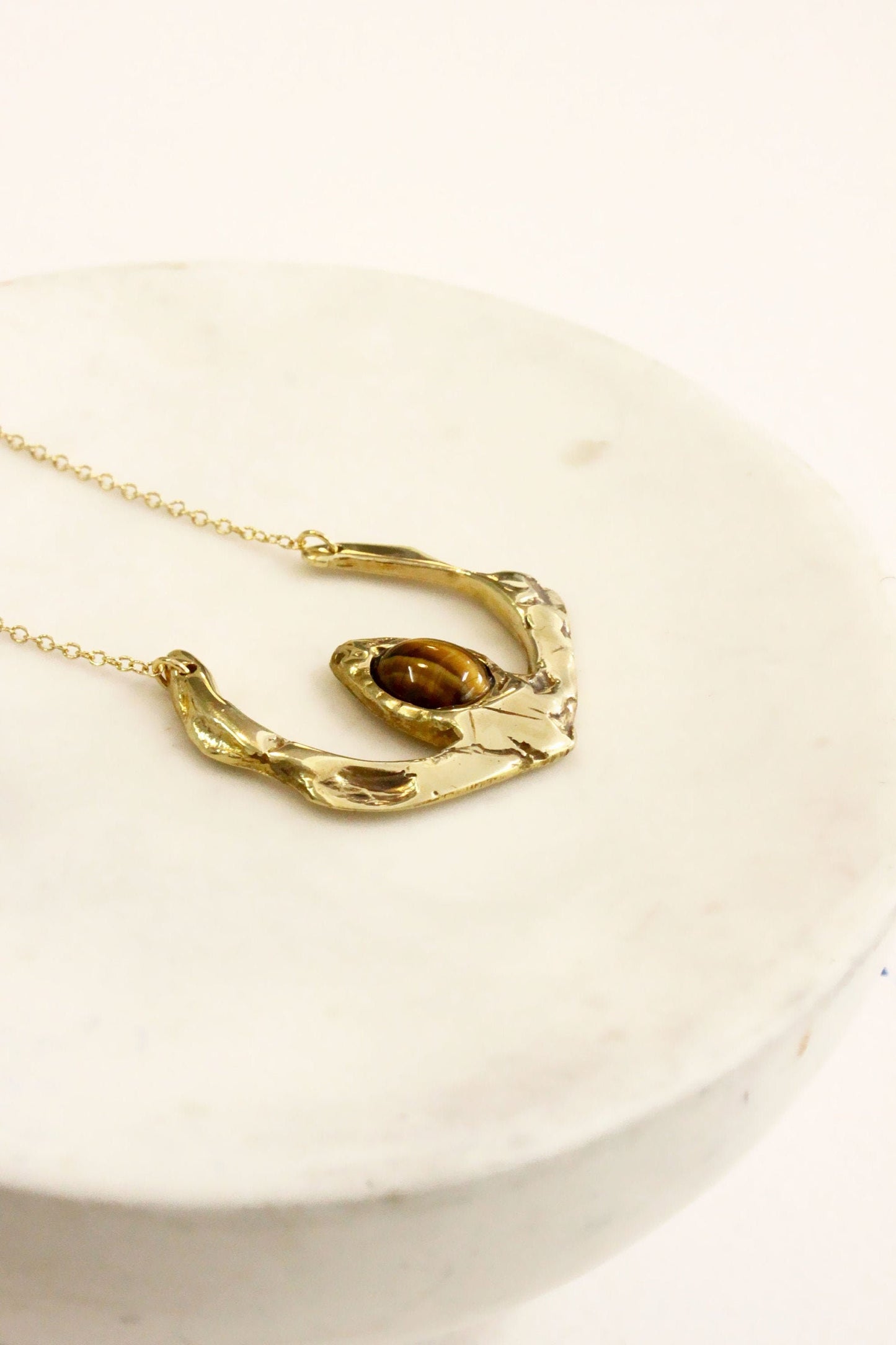Gold necklace with a unique tigers eye crystal