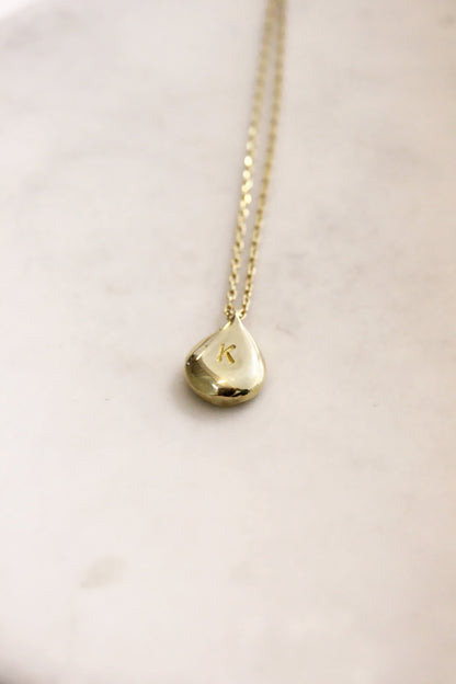 Gold necklace with a teardrop-shaped personalized initials monogram 