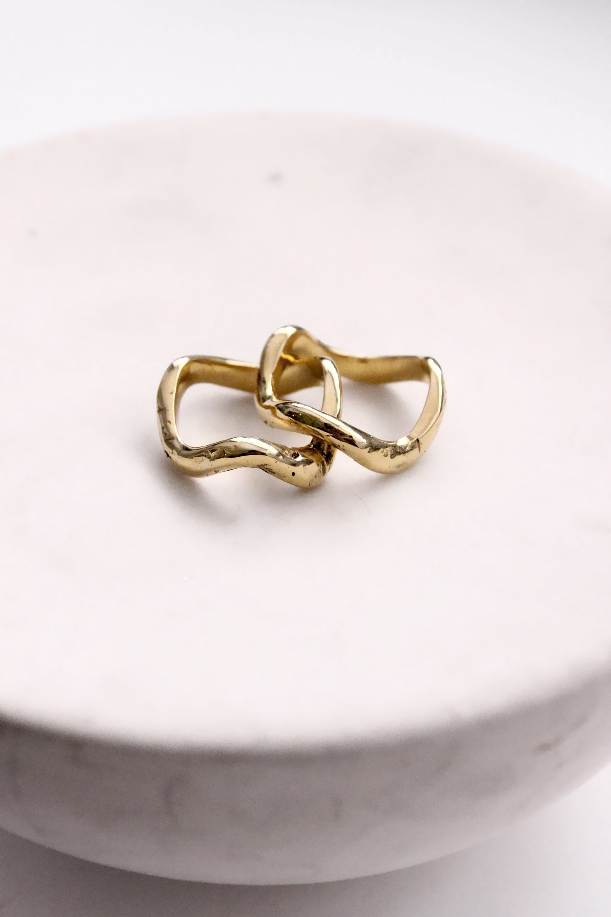 Two gold rings wavy molten liquid 