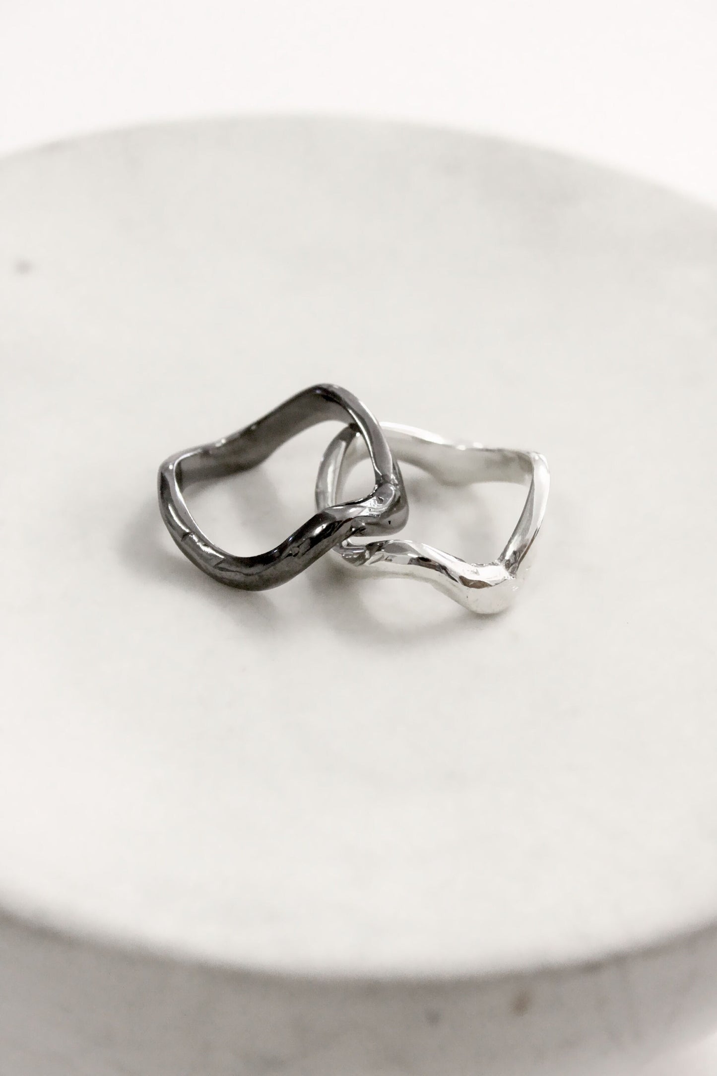 Two silver rings wavy molten liquid 