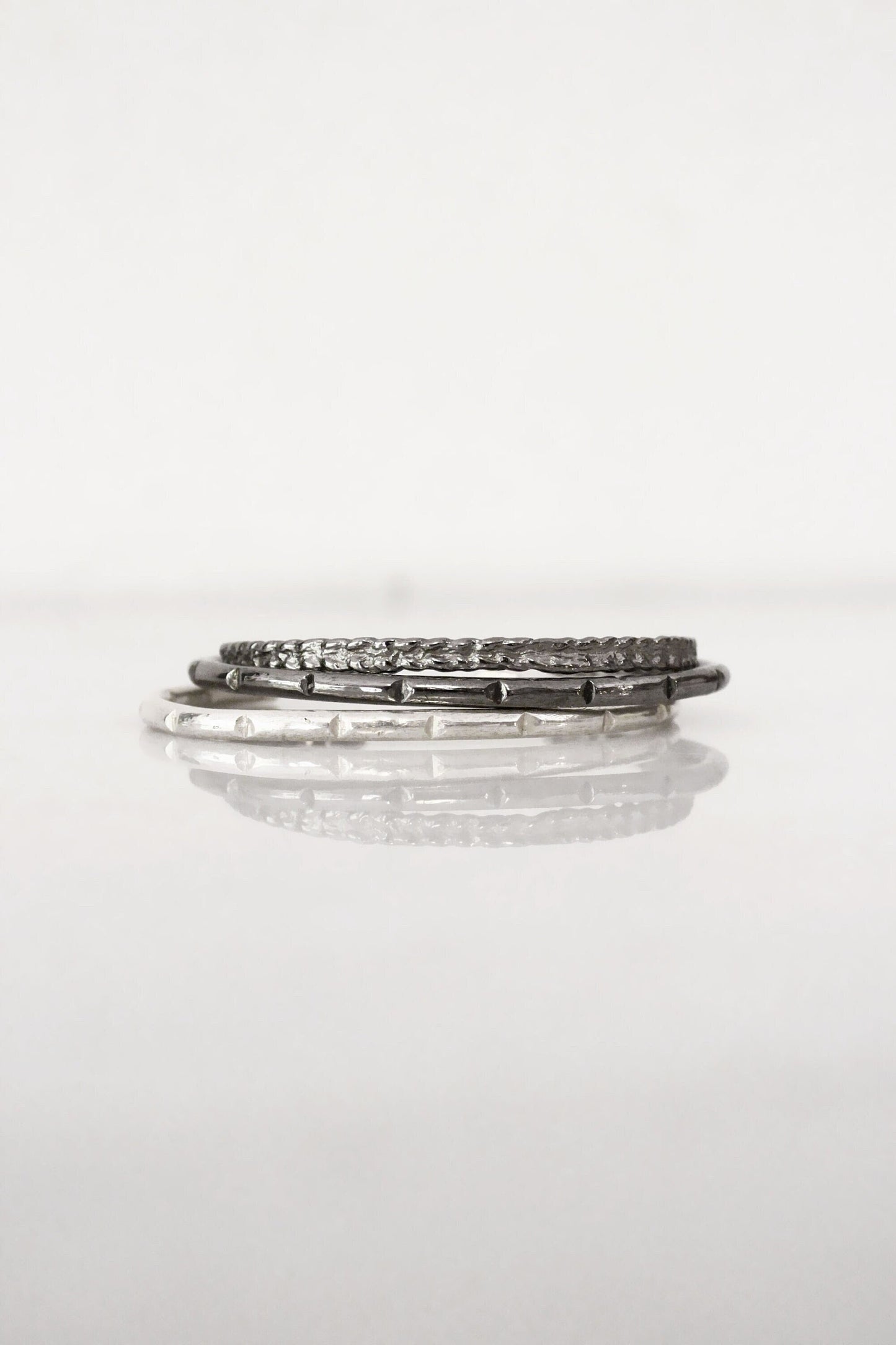 Stack of silver minimal bar cuff 