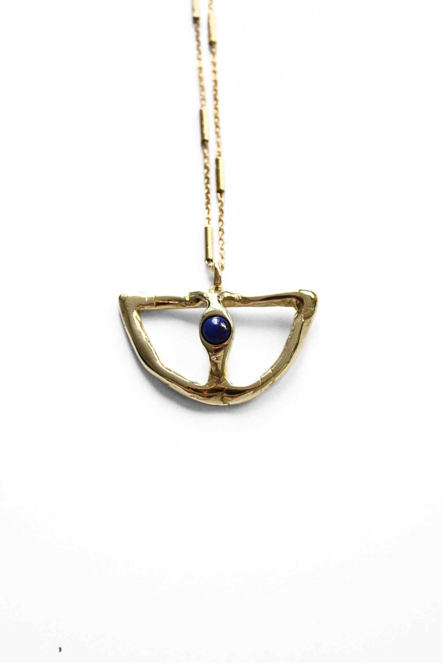 Gold necklace with a blue gemstone pendant