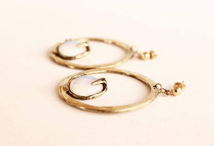 Gold hoop earrings on a light beige background