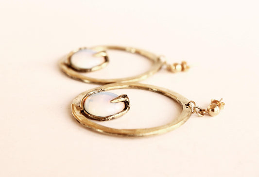 Gold hoop earrings on a light beige background